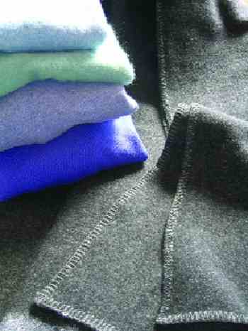 STEP 1: Find four or five 100 percent wool sweaters. Thrift stores are often treasure troves of pullover sweaters; these cost about $2 each. Washing them in hot water and then machine drying shrinks, tightens, and “felts” the wool, making it thicker and virtually fray-free when cut. Choose sweaters that have no acrylic or nylon in them, as synthetic fibers will prevent the wool from felting. Large or extra-large sweaters are best so there’s still plenty of material left after they shrink.